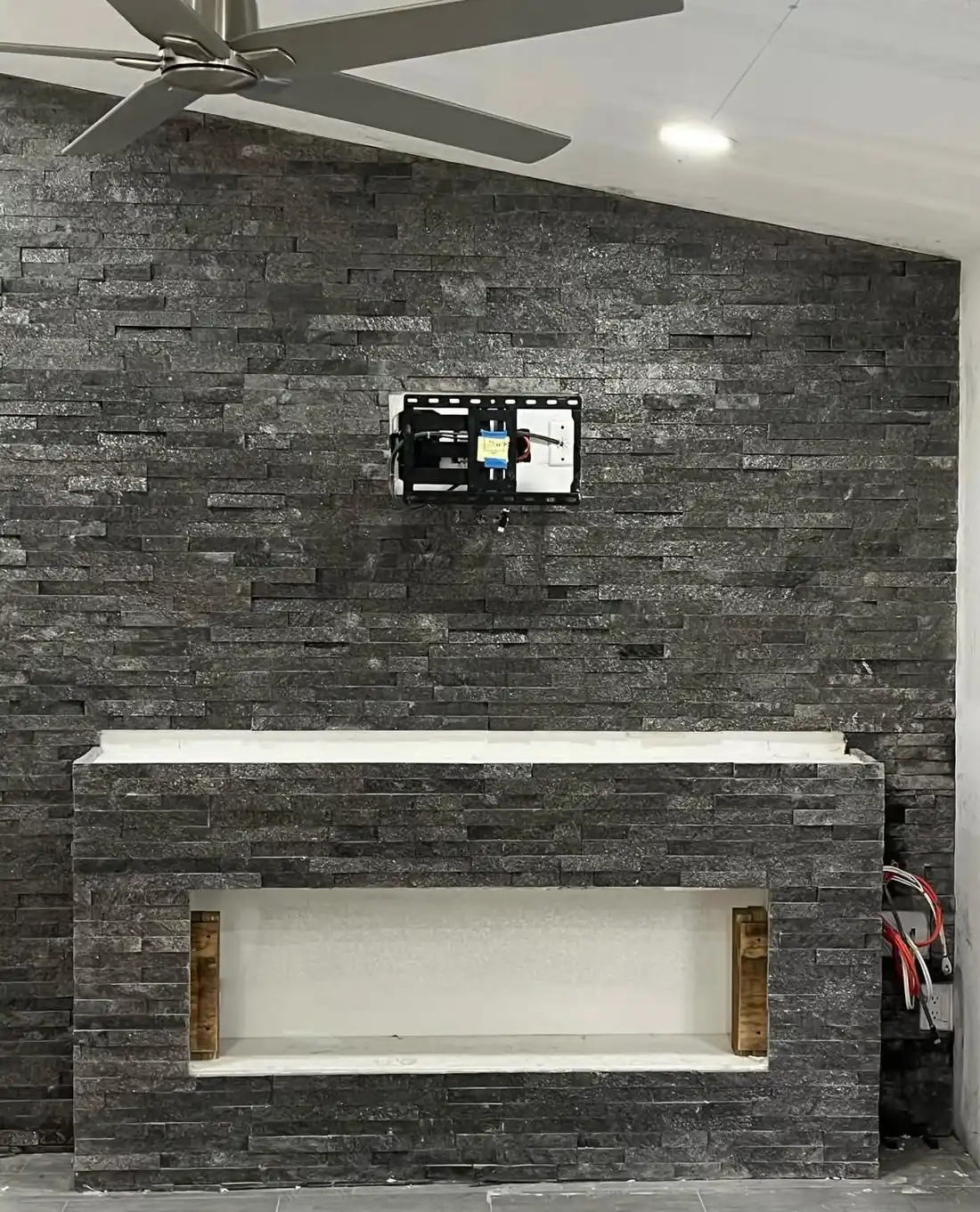 Floor-to-ceiling stacked stone fireplace wall installed by SG Tile Remodeling